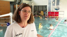 Daniela Linden, Kursleiterin DLRG Düren steht an einem Becken in dem Kinder schwimmen
