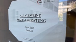 Schild der Sozialberatung in Siegburg: Ein Papierbogen verweist auf den Beratungsraum im ersten Stock bei der AWO- 