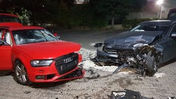 Links ein roter Audi, der vorne stark beschädigt ist, rechts ein graues Auto, ebenfalls stark beschädigt.
