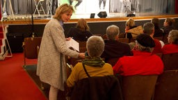 Eine WDR-Redakteurin reicht einer Frau im Publikum ein Mikrofon für einen Wortbeitrag
