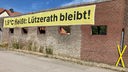 Ein Banner mit der Aufschrift "Lützerath bleibt!" an einer Mauer