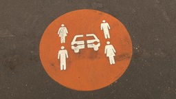 Orangenes  Carsharing Logo, auf einen Parkplatz gemalt