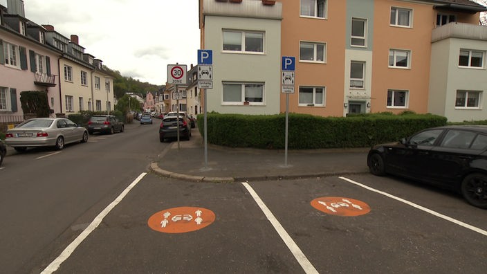 Zwei Parkplätze mit orangenem Car-Sharing Logo