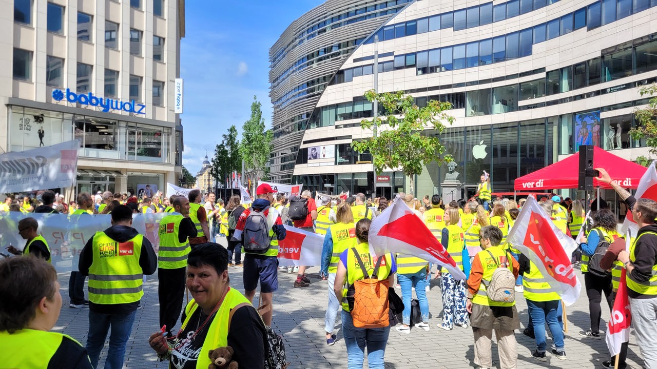 Hunderte Mitarbeitende streiken mit gelben Westen und Verdi-Fahnen in der Düsseldorfer Innenstadt.