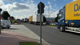 Längere LKW-Warteschlange auf der Straße in einem Gewerbegebiet