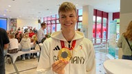 Taliso Engel hält seine Goldmedaille hoch