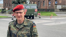 Oberst Stephan Kurjahn steht vor einem Fahrzeug der Bundeswehr