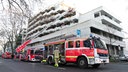 Feuerwehrauto vor Krankenhaus. Ausgefahrene Drehleiter zum oberen Etage.