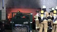 Mehrere Feuerwehrmänner löschen Brand in Garage in Düsseldorf