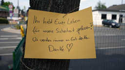 Auf einem gelben Papierschild an einem Baum steht: "Ihr habt Euer Leben für unsere Sicherheit gegeben! Wir werden immer an Euch denken. Danke"