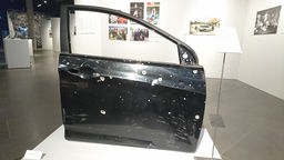 Eine, durch Schusswaffen zerstörte Autotür, in der Ukraine-Ausstellung in Bonn.