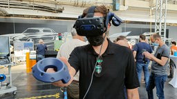 Ein Mitarbeiter von Ford trägt eine VR-Brille bei einer Schulung zur neuen Produktion reiner Elektro-Autos