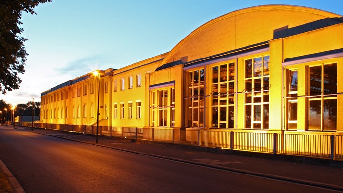 Das Bild zeigt die Alfred-Schütte-Allee im Kölner Stadtteil Poll neben dem Schütte-Werksgebäude.