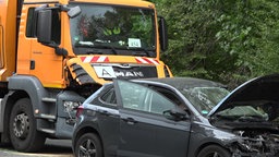 Zerstörtes Auto und Müllwagen nach Kollision