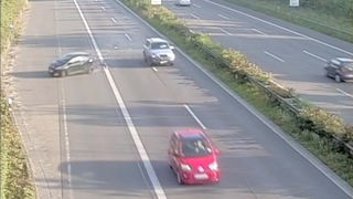Man sieht ein schleuderndes Auto auf der Autobahn