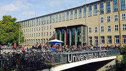 Blick auf ein Gebäude der Uni Köln, im Vordergrund viele Fahrräder