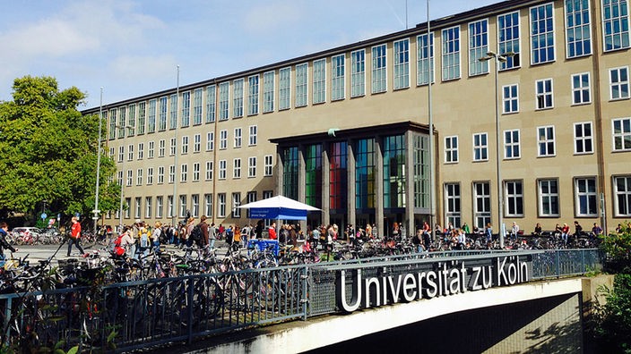 Blick auf ein Gebäude der Uni Köln, im Vordergrund viele Fahrräder