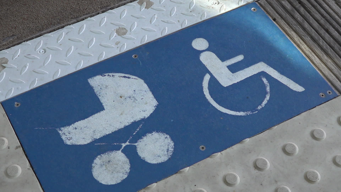 Ein blaues Schild mit weißem Kinderwagen und einer Person im Rollstuhl.