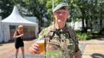 Ein Soldat mit Bierbecher in der Hand lächelt in die Kamera