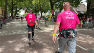 Zwei Männer von hinten mit pinken Shirts, darauf der Schriftzug: The Walk of the World
