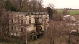 Drohnen-Ansicht auf die Villa Buth, ein verfallenes Haus in einem verwilderten Garten