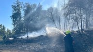 Feuerwehrleute löschen einen Waldbrand in Windeck