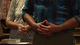 Hände von Pilgern, die in der Wallfahrtskirche beten