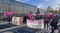 Demonstranten vor dem Unigebäude in Köln mit Textbannern und Fahnen