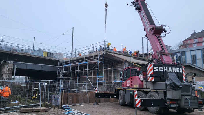 Ein Kran und eine Bahnbrücke