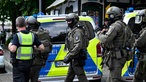 Mehrere Polizei-Einsatzkräfte mit Sturmhauben und schusssicheren Westen.