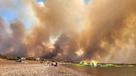 Dichte Rauchwolken eines Waldbrandes steigen auf der griechischen Insel Rhodos in den Himmel. 