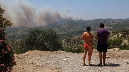 Zwei Touristen aus der Schweiz schauen auf den Rauch in der Nähe vom Dorf Archangelos auf Rhodos