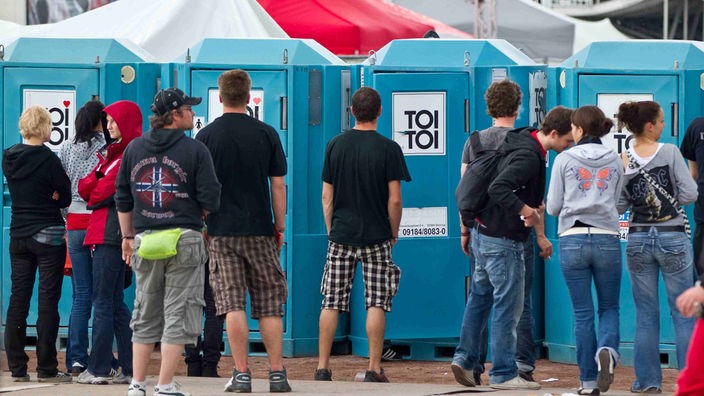 Festival-Besucher stehen vor den Toiletten Schlange