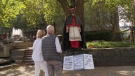 Zwei Menschen stehen vor der Hengsbach Statue