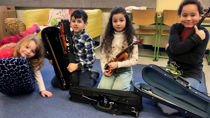 Geigenschüler mit ihren Instrumenten in der Grundschule
