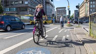 Zwei Fahrradfahrer fahren auf Radweg in Essener Innenstadt