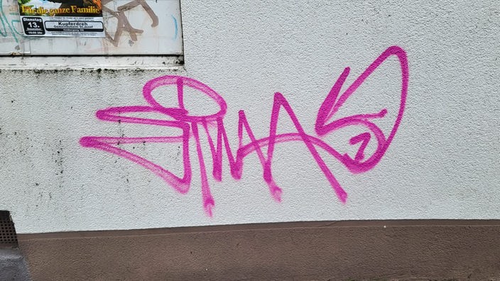 Ein pinkes Graffiti auf einer Hauswand
