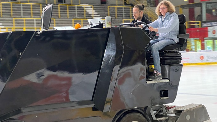 Zwei Personen fahren auf der Eisfläche