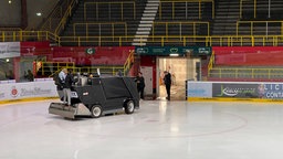 Zwei Personen fahren auf der Eisfläche