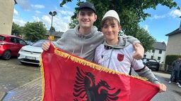 Zwei Albanien-Fans haben eine Albanien-Flagge in der Hand