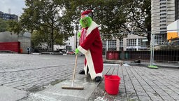 Der Grinch entfernt die heimliche Werbung für Crange auf dem Dortmunder Weihnachtsmarkt 