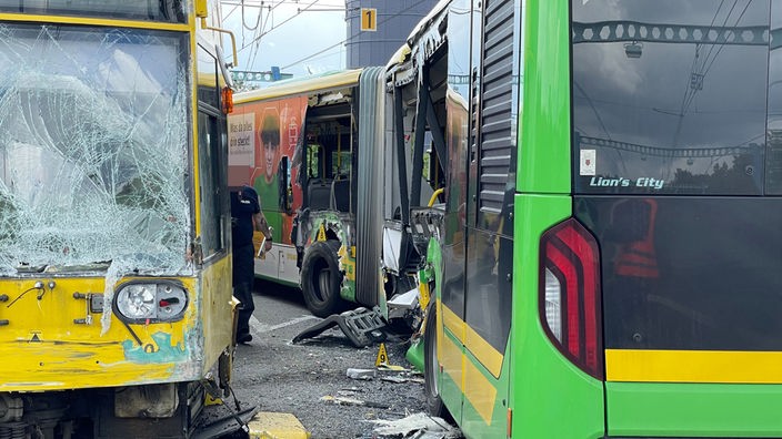 Eine beim Unfall zerstörte Straßenbahn und ein Bus