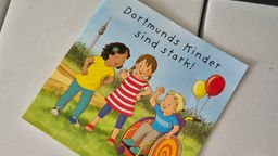 Das Cover des neuen Bilderbuchn von zwei Dortmundern. Auf dem Cover sind drei Kinder zu sehen.