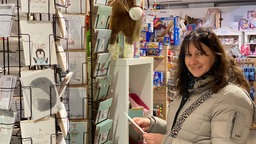 Kerstin Müller hält eine Karte in dem Bochumer Spielwarenladen.