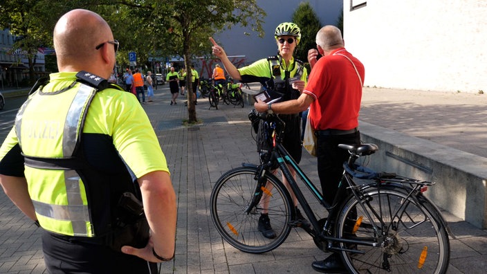 Eine Polizistin spricht mit einem Fahrradfahrer