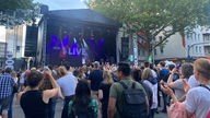 Vor einer Bühne in der Bochumer Innenstadt stehen Menschen, auf der Bühne steht der Sänger Gregor Hägele 