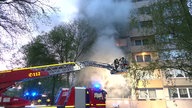 Die Feuerwehr löscht ein Feuer in einem brennenden Gebäude.