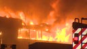 Ein Industriegebäude steht lichterloh in Flammen und Rauch steigt auf.