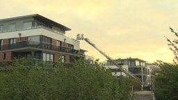 Auf dem Bild ist ein Penthouse am Phoenixsee zu sehen. Die Feuerwehr ist an einem der Balkone mit einer Drehleiter im Einsatz