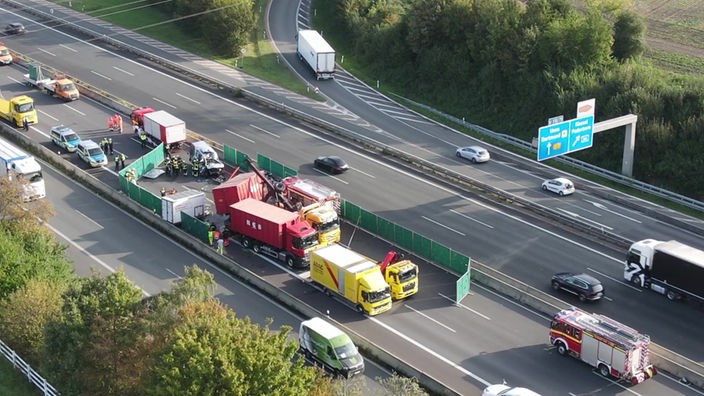 Die Unfallstelle auf der A1 im Kreuz Dortmund/Unna von oben gesehen, es sind ein stark zerstörter Kleintransporter, ein LKW, Bergungsfahrzeuge und Einsatzkräfte zu sehen.